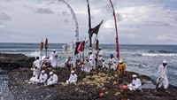 Pada saat upacara adat di Bali satu ini berlangsung, pemangku Hindu akan memercik air suci ke kepala setiap penduduk agar membersihkan semua kotoran dan hal buruk dalam tubuh sehingga jiwa dan raga kembali suci. Ulet Ifansasti/Getty Images  