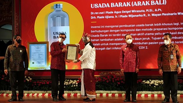 Menteri Hukum dan Hak Asasi Manusia (Menkumham) RI, Yasonna Hamonangan Laoly menyerahkan sertifikat hak kekayaan intelektual (HaKI) untuk kain tenun endek Bali di Taman Budaya Provinsi Bali, Jum'at (5/2/2021)