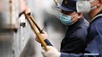 Petugas membersihkan dengan detail, lengkap dengan maskernya. Foto: Dok. Xinhua/Wang Jianwei