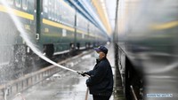 Setelah disikat, badan kereta disemprot dengan air. Foto: Dok. Xinhua/Wang Jianwei