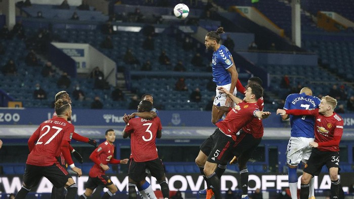 LIVERPOOL, ENGLAND - DECEMBER 23: Dominic Calvert-Lewin of Everton wins a header under pressure from Harry Maguire and Axel Tuanzebe of Manchester United during the Carabao Cup Quarter Final match between Everton and Manchester United at Goodison Park on December 23, 2020 in Liverpool, England.  A limited number of fans (2000) are welcomed back to stadiums to watch elite football across England. This was following easing of restrictions on spectators in tiers one and two areas only. (Photo by Clive Brunskill/Getty Images)