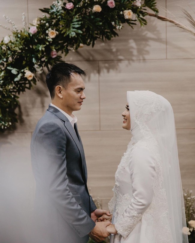 Gaun dilengkapi hijab dengan model sederhana dan veil panjang. Tampak simpel namun tak mengurangi kesan mewah. Foto: Instagram/@ikkenurjanah0518, @zoie.pictures