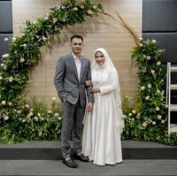 Ikke Nurjanah tampil sederhana dengan gaun putih dan hijab simpel di hari pernikahannya. Gaun berpotongan A-line dengan detail bordir dan lace rancangan Defrico Audy.  Foto: Instagram/@ikkenurjanah0518, @zoie.pictures