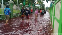 Sejumlah warga melintas di Jalan Pelita III yang terendam banjir.