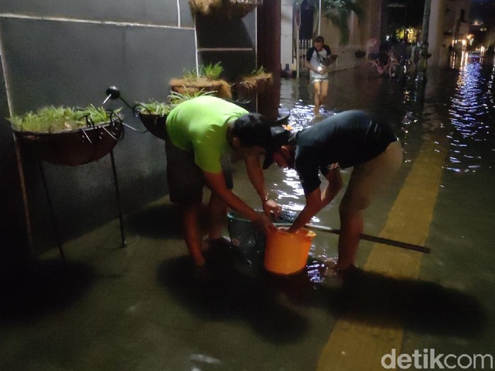 Berburu ikan saat banjir di Kota Lama, Semarang, Sabtu (6/2/2021) malam.