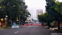 Polisi tampak berjaga dan memasang traffic cone untuk menghalangi kendaraan masuk ke wilayah kota.