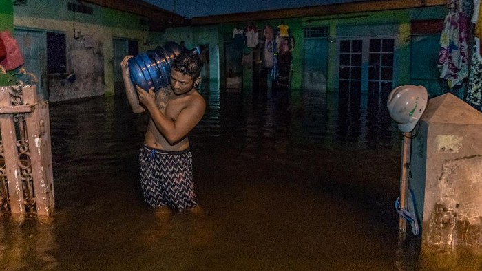BANJIR RENDAM 76 KELURAHAN DI KOTA SEMARANG Seorang warga memasak di dalam rumahnya yang terendam banjir di Kelurahan Tanjung Mas, Semarang, Jawa Tengah, Sabtu (6/2/2021). Menurut data yang dihimpun Badan Penanggulangan Bencana Daerah (BPBD) Kota Semarang, sekitar 76 kelurahan yang tersebar di 10 kecamatan di Kota Semarang terendam banjir akibat curah hujan tinggi sejak Jumat (5/2) malam. ANTARA FOTO/Aji Styawan/wsj.