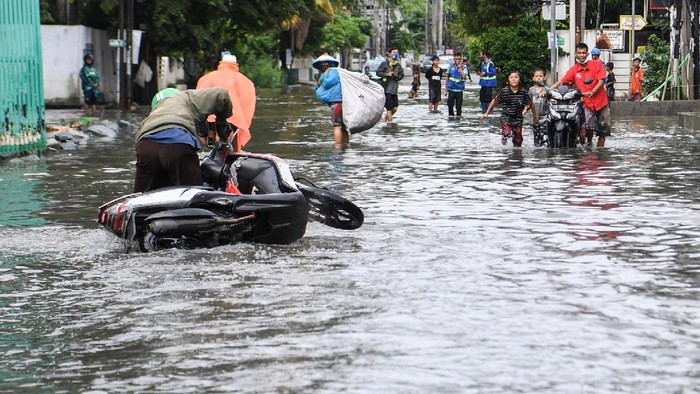 BANJIR RENDAM PERUMAHAN GREEN GARDEN JAKARTA Warga terjatuh saat melintasi genangan air di kawasan perumahan Green Garden, Jakarta, Minggu (7/2/2021). Hujan deras yang mengguyur Jakarta pada Minggu (7/2) dini hari menyebabkan kawasan tersebut tergenang air dengan ketinggian 30-50 cm sehingga mengganggu aktivitas warga. ANTARA FOTO/Hafidz Mubarak A/aww.