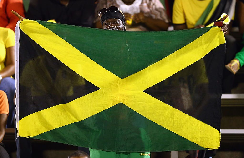 KINGSTON, JAMAICA - JUNE 07:  A fan waves a flag before the USA takes on Jamaica in the FIFA 2014 World Cup Qualifier at National Stadium on June 7, 2013 in Kingston, Jamaica.  (Photo by Streeter Lecka/Getty Images)