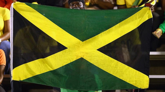 KINGSTON, JAMAICA - JUNE 07:  A fan waves a flag before the USA takes on Jamaica in the FIFA 2014 World Cup Qualifier at National Stadium on June 7, 2013 in Kingston, Jamaica.  (Photo by Streeter Lecka/Getty Images)
