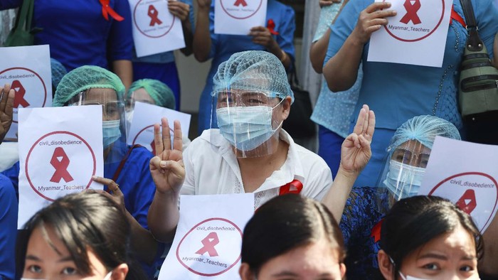 Staffers of the University Hospital hold signs that read 