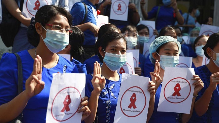 Staffers of the University Hospital hold signs that read 