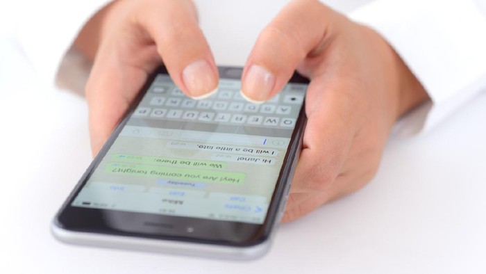 İstanbul, Turkey - July 14, 2015: Hands holding a iPhone 6 Plus displaying WhatsApp messaging application. iPhone is a touchscreen smart phone produced by Apple Inc.