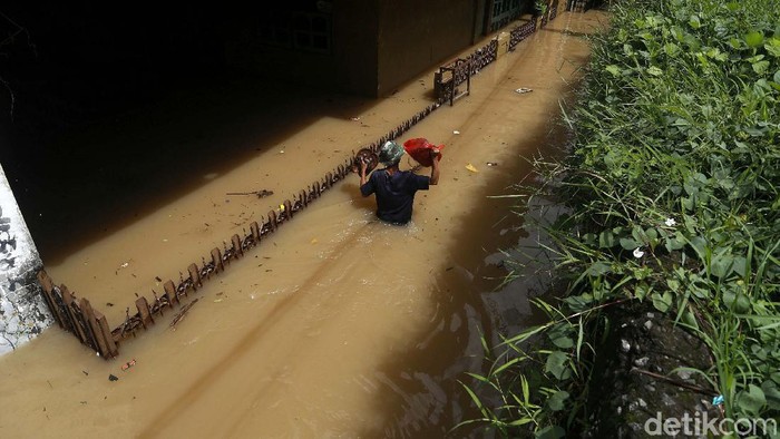 Banjir masih merendam kawasan Rawajati, Jakarta, Senin (08/02/2021). Warga nekat menerobos banjir yang cukup tinggi tersebut.