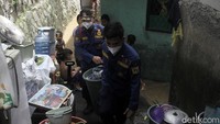 Petugas pemadam kebakaran ikut membantu mengevakuasi barang-barang milik warga.
