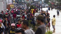 Sejumlah warga berenang melintasi banjir di Desa Dawuan Tengah, Cikampek, Karawang, Jawa Barat. Meluapnya Sungai Cikaranggelam mengakibatkan ratusan rumah warga terendam.