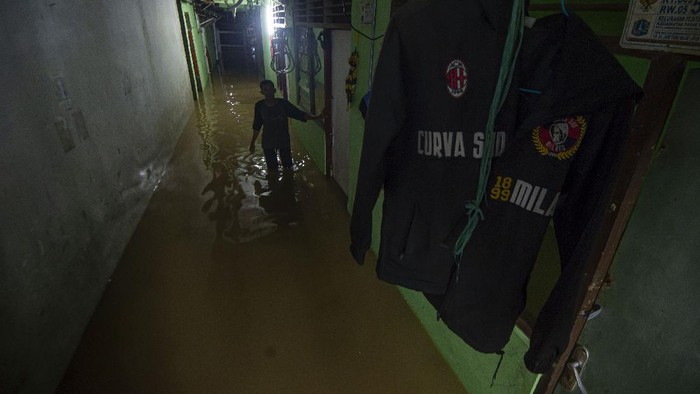 Warga melintasi banjir yang melanda lingkungan tempat tinggalnya di Pejaten Timur, Pasar Minggu, Jakarta, Minggu (7/2/2021). Banjir setinggi 30-150 cm yang melanda tiga RW di Pejaten Timur itu disebabkan oleh luapan air Sungai Ciliwung. ANTARA FOTO/Aditya Pradana Putra/rwa.