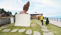 Patung tangan yang mengarah ke Danau Toba.