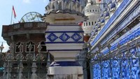 Bangunan pesantren yang megah dengan menara dan nama pesantren yang tertulis di bagian atas dinding pesantren.