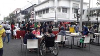 Pengunjung tengah duduk santai sembari menikmati makanan yang mereka beli.