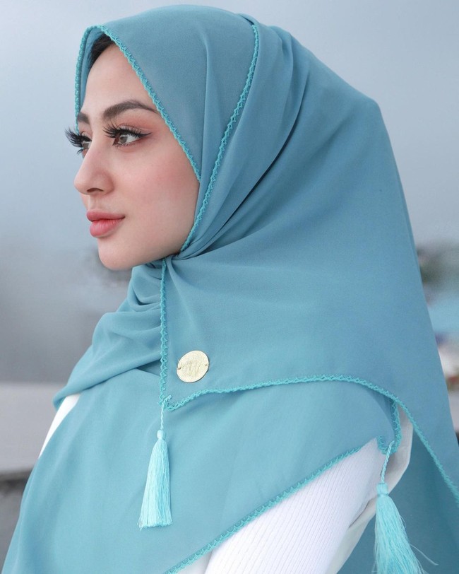 Hijab pashmina dijual Margin dengan harga Rp 125 ribu. Dalam foto ini, Margin tampak tidak menggunakan jarum pentul atau peniti. Ia hanya melilitkan hijabnya dan disematkan ke bawah dagu. Foto: Dok. Instagram @mwbymargin_catalog.
