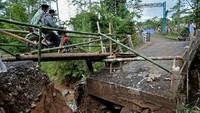 Pengendara melintasi jembatan darurat yang terpasang di Singajaya, Kabupaten Garut, Jawa Barat, Senin (8/2/2021). 