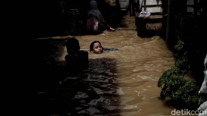 Banjir merendam kawasan Kebon Pala, Kampung Melayu, Jakarta. Anak-anak ini justruk asyik bermain di genangan banjir.