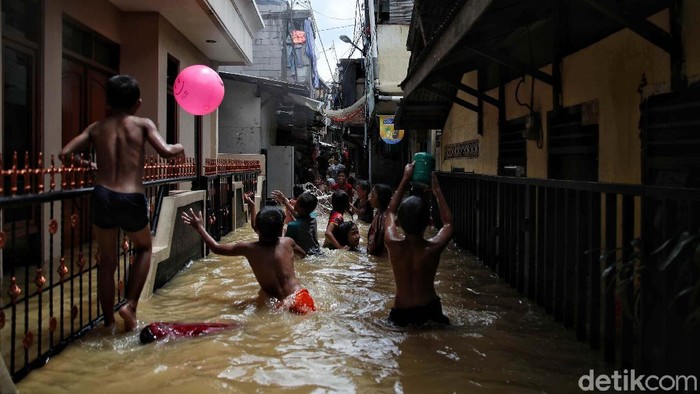 Banjir merendam kawasan Kebon Pala, Kampung Melayu, Jakarta. Anak-anak ini justruk asyik bermain di genangan banjir.