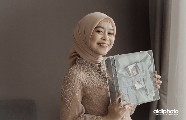 Sebelum acara akad nikah Margin, Lesti Kejora menunjukkan hampers box pemberian sang sahabat berupa dres cantik dengan wajah sumringah. Foto: Instagram @aldiphoto.