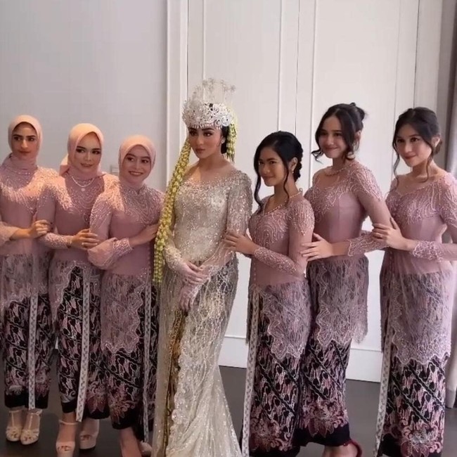 Pada saat akad nikah Margin dan Ali Syakieb, para bridesmaid memakai busana kebaya pastel pink rancangan Gugi Nugraha. Lesti Kejora yang ikut menjadi bridesmaid memakai hijab yang dililit rapi ke belakang, agar memperlihatkan detail payet kebayanya. Ia menambahkan inner hijab bahan kaus dengan warna yang senada. Foto: Dok. Instagram @leslars_bali.