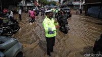 Polisi tampak mengatur arus lalu lintas.