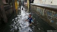 Mereka berenang di jalan yang ubah menjadi sungai.