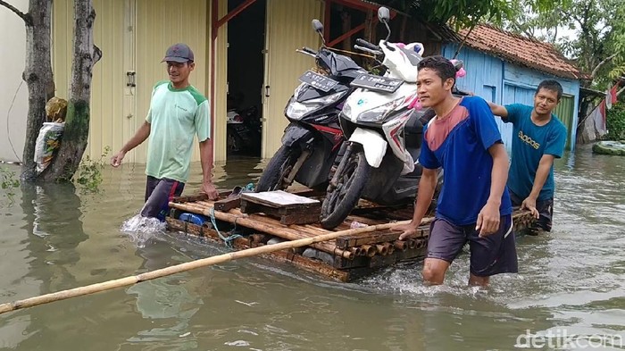 Sejumlah warga menyewakan rakit untuk evakuasi barang-barangnya di tengah kepungan banjir Kota Pekalongan, Senin (8/2/2021)