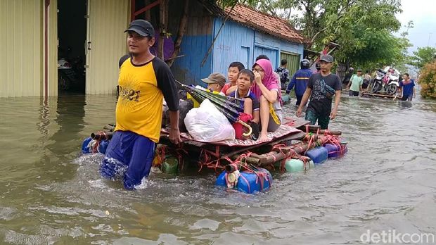 Sejumlah warga menyewakan rakit untuk evakuasi barang-barangnya di tengah kepungan banjir Kota Pekalongan, Senin (8/2/2021)