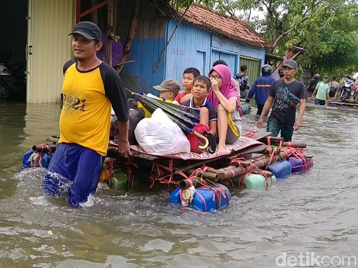 Sejumlah warga menyewakan rakit untuk evakuasi barang-barangnya di tengah kepungan banjir Kota Pekalongan, Senin (8/2/2021)