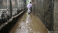 Sisa air yang surut juga meninggalkan lumpur tebal di gang jalan.