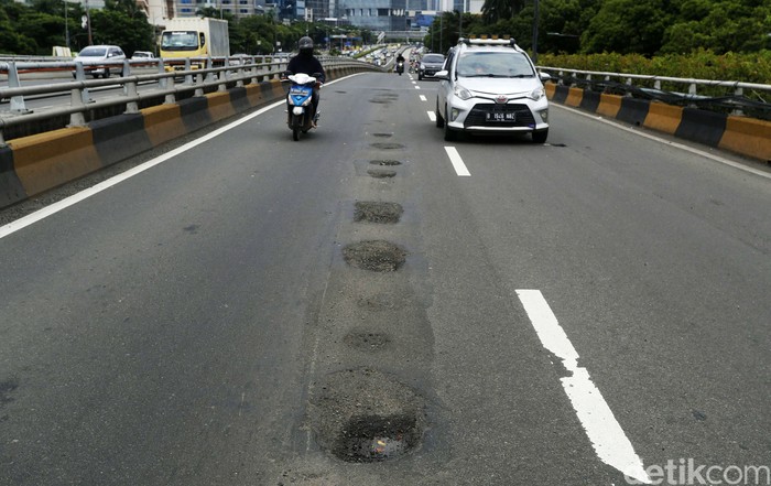 Hujan mulai sering mengguyur Jakarta. Kerusakan jalan raya di ibukota pun kian parah, seperti terlihat di Jalan Gatot Subroto, Selasa (9/2/2021).