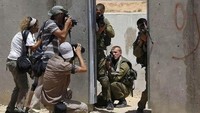 Para jurnalis foto mengambil gambar saat tentara Israel saat mengamankan aksi unjuk rasa di Palestina. Getty Image