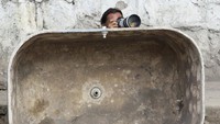 Seorang fotografer bersembunyi di balik tong baja, keselamatan jiwa menjadi hal utama dalam peliputan didaerah konflik. Getty Image