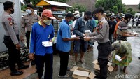 Sejumlah polisi membagikan nasi gratis untuk warga di kawasan Malioboro, Yogyakarta, Rabu (10/2/2021).