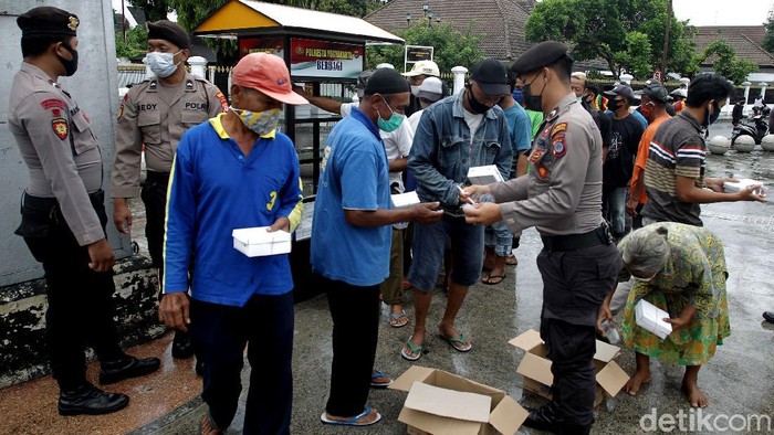 Sejumlah relawan dan petugas kepolisian membagikan ratusan nasi gratis bagi masyrakat di Yogyakarta. Sekitar 200 kotak nasi dibagikan secara gratis setiap hari.