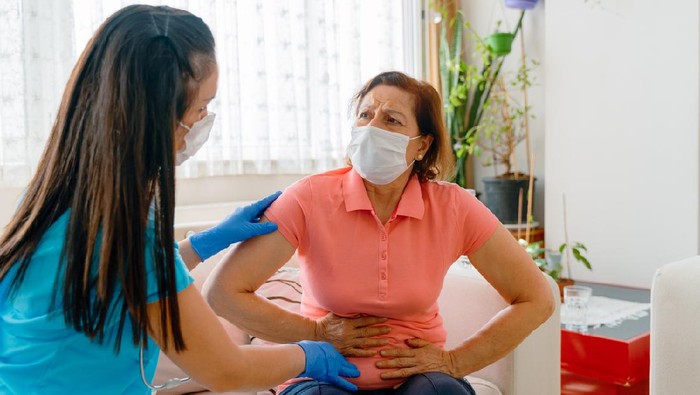 Abdominal pain patient woman having medical exam with doctor on illness from stomach cancer, irritable bowel syndrome, pelvic discomfort, Indigestion, Diarrhea, GERD (gastro-esophageal reflux disease)