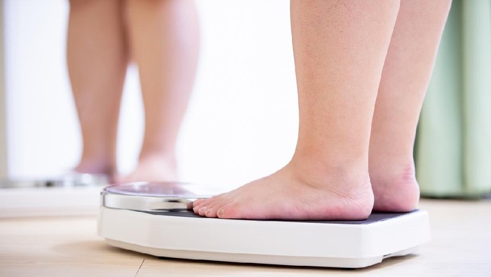 ilustrasi obesitas plus size asian girl look mirror and measure her weight by scale