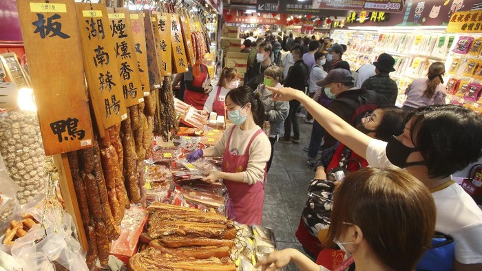 People wear face masks to help curb the spread of the coronavirus as they shop for the upcoming Chinese New Year celebrations at a market in Taipei, Taiwan, Wednesday, Feb 10, 2021. Taiwanese shoppers started hunting for delicacies, dried goods and other bargains at the market ahead of the Lunar New Year celebrations which according to the lunar calendar will take place on Feb. 12. (AP Photo/Chiang Ying-ying)