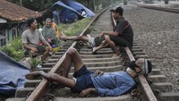 Sejumlah warga pengungsi banjir beristirahat di lintasan rel kereta yang tidak terpakai di Desa Waringinjaya, Cikarang, Kabupaten Bekasi, Jawa Barat, Selasa (9/2/2021). MANTARA FOTO/Fakhri Hermansyah.
