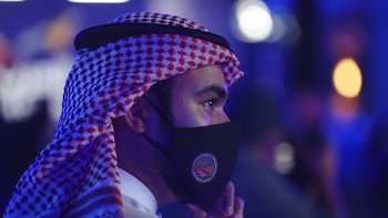 Seorang warga mendengarkan dengan seksama keterangan dari sang menteri sembari memakai masker di tengah pandemi Corona. Foto: AP/Kamran Jebreili