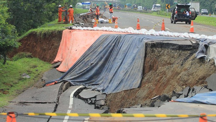 Pekerja memeriksa kondisi jalan tol yang ambles di ruas tol Cikopo-Palimanan (Cipali) KM 122, Kabupaten Subang, Jawa Barat, Rabu (10/2/2021). Kementerian Pekerjaan Umum dan Perumahan Rakyat (PUPR) dan Astra Tol Cipali akan melakukan percepatan penanganan amblesnya jalan di ruas tol Cipali KM 122 dengan membuat lajur sementara sepanjang 200 meter dengan perkiraan waktu pengerjaan selama 10 hari. ANTARA FOTO/Dedhez Anggara/rwa.
