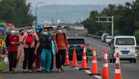 Warga berjalan di jalan tol yang dibuka PT Jasa Marga (Persero) untuk membantu pejalan kaki maupun pengendara sepeda motor yang ingin memutar arah karena jalur Pantura Kaligawe terendam banjir di Semarang, Jawa Tengah, Selasa (9/2/2021). ANTARA FOTO/Aji Styawan.
