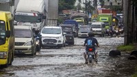 Sebuah sepeda motor berjalan melawan arah di jalan Pantura yang terdampak banjir di Kabupaten Pekalongan, Jawa Tengah, Senin (8/2/2021). ANTARA FOTO/Harviyan Perdana Putra.
