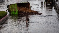 Sebuah truk terguling akibat terperosok banjir yang merendam jalur Pantura Kaligawe, Semarang, Jawa Tengah, Selasa (9/2/2021). ANTARA FOTO/Aji Styawan.